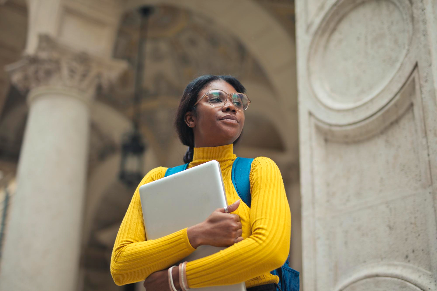portrait-young-woman-with-laptop-hands-outside-school